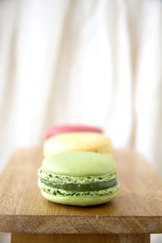close up green macaron in line on wooden