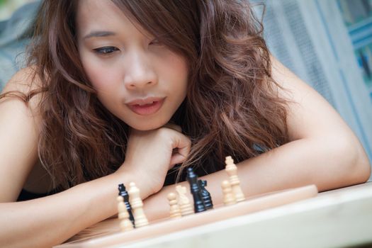 Asian woman playing chess at outdoor