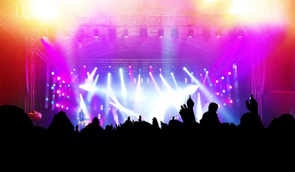 People with hands up having fun on a music concert / disco party. Dynamic motion.