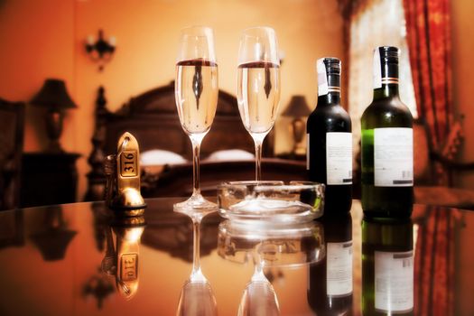 Luxury interior - hotel room with elegant service. Wine, glasses, antique keys on stylish furniture