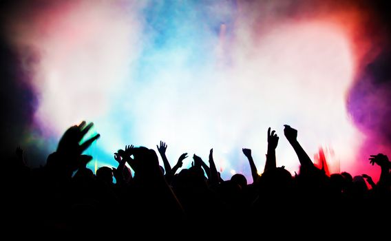 People with hands up having fun on a music concert / disco party.