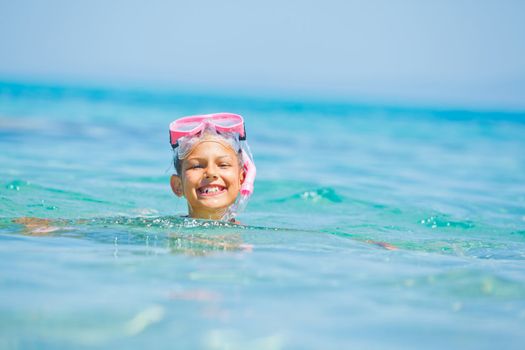 Cute girl snorkelling swimming in the transparent sea