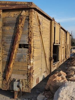 Abandoned wooden railway car standing on props