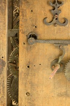 Retro wooden grunge clock box and mechanism gear wheel residue closeup
