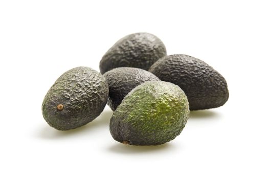 Grouping of fresh avocados photographed on a white background.