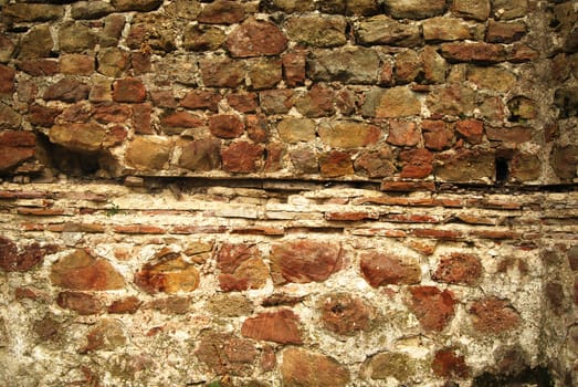 Ancient roman wall, stones, ceramic bricks closeup