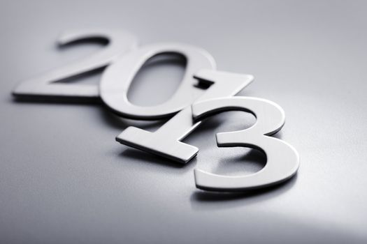 Metallic numbers used for "2013" in a pile.