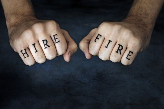 Conceptual image of a man with "HIRE" and "FIRE" fake tattoos.