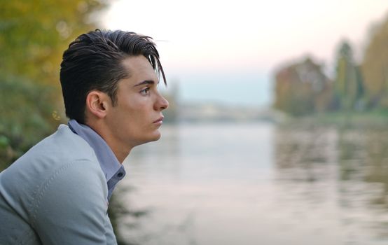 Profile portrait of handsome young male model on river banks