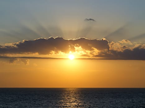 rays of the setting sun breaks through the clouds over the sea