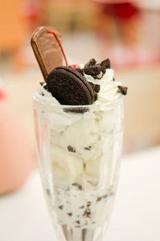 Vanilla ice cream in bowl with chocolate cookies , banana and cherry ,