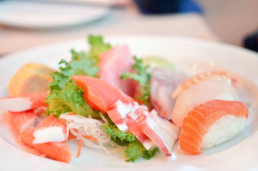 Mixed sushi and sashimi served with fresh vegetable