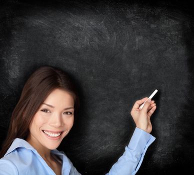 Teacher teaching or young student writing on blackboard / chalkboard with chalk an copy space for your text