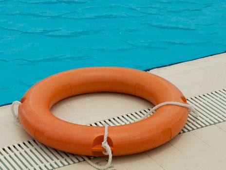 Orange Safety Lifebelt on Edge of Swimming Pool closeup