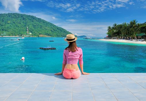 Woman at beach jetty wearing hat