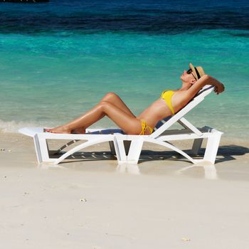 Girl on a tropical beach with hat