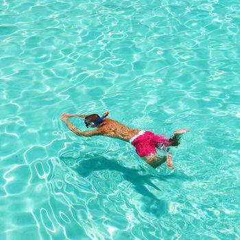 Man snorkeling in crystal clear turquoise water at tropical beach