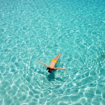 Woman snorkeling in crystal clear turquoise water at tropical beach