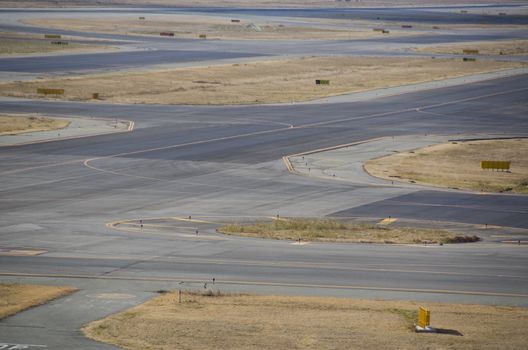 Detail of a runway at a airport with asphalt and grass