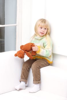 Little Girl 3 years with a brown teddy bear