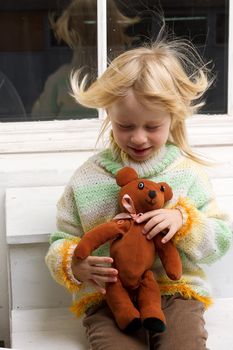  little girl with a toy in the hands with flowing hair from the fan