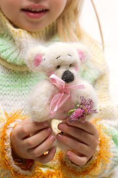 Handmade teddy bear close-up in the hands of a child