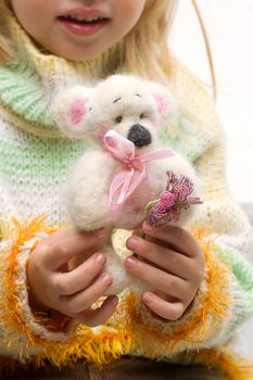 Handmade teddy bear close-up in the hands of a child