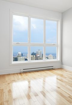 City skyscrapers seen through the big window of an empty room.