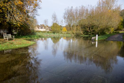Seat overlooking a deep river at road ford on Shill Brook at Shilton Oxfordshire