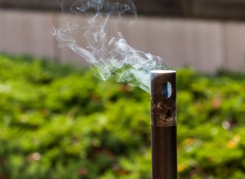 Smoke from cigarettes still burning in waste disposal unit