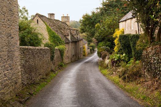 Narrow lane in vilalge of Minster Lovell in Cotswolds with stone cottages