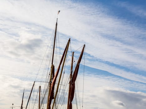 Thames sailing ship or barge with masts and sails by dock in Faversham Kent UK