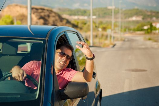 Guy gesturing out of the window of his car