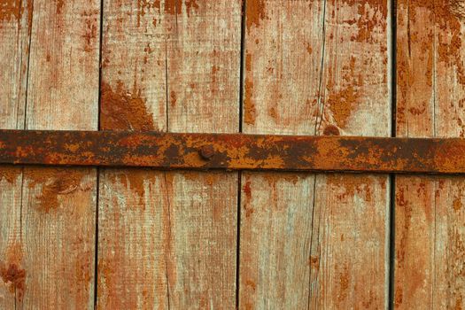 Old wooden door with rusted metal bar