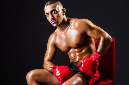 Boxer with red gloves in dark room