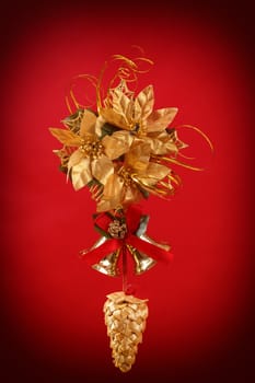 christmas decoration with cone , bells and golden flower on red background