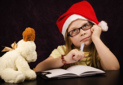 Girl who thinks what to write to Santa Claus