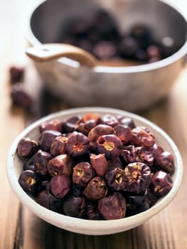 close up of a bowl of dried round red chilies