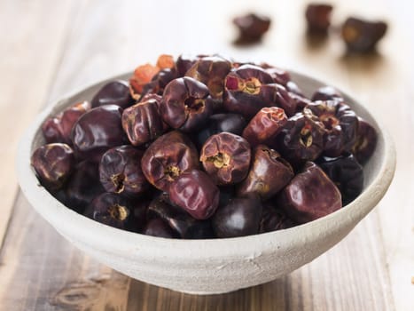 close up of a bowl of dried round red chilies