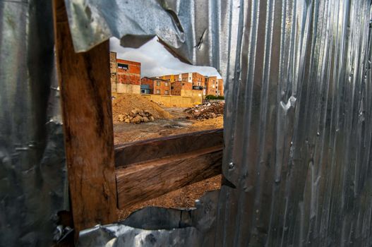 View of a construction site through a hole in a fence