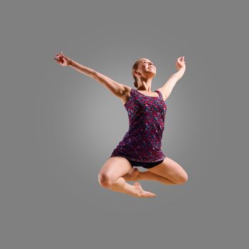 dancer jumping on a gray background, having a fun