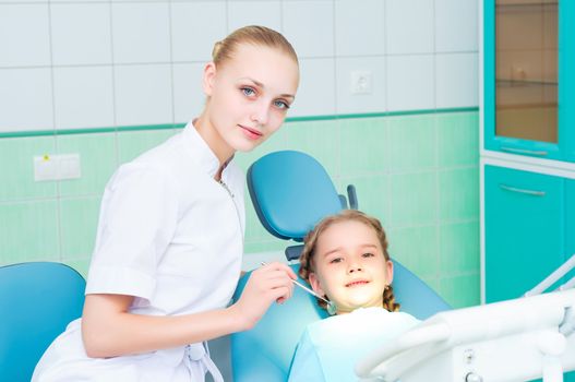 young doctor woman and girl in dentist office, regular visits to the dentist