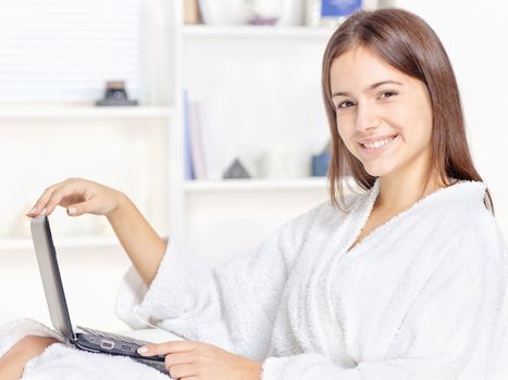girl in bathrobe at home with computer