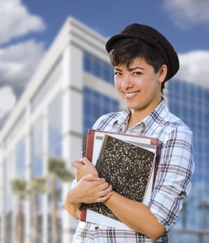 Attractive Mixed Race Female Student Holding Books in Front of Building.