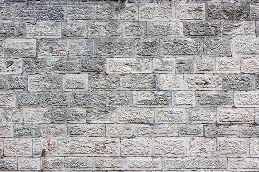 An old white brick wall showing much detail, patterns, and texture.