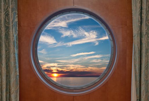 View of a sunset through the porthole of a cruise ship