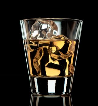 Glass of whiskey on the rocks on black background