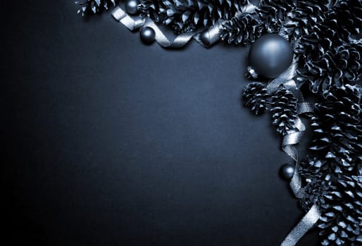 Monotone grunge Christmas decorations with pine cones, ornaments and ribbon in cool gray blue tones