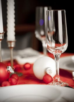 Christmas table setting in red and white, focus on front glass
