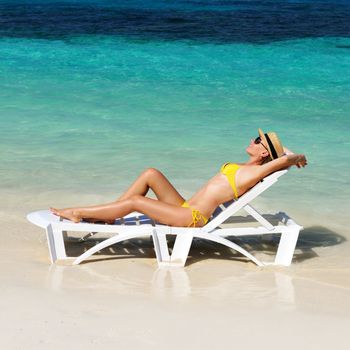 Girl on a tropical beach with hat